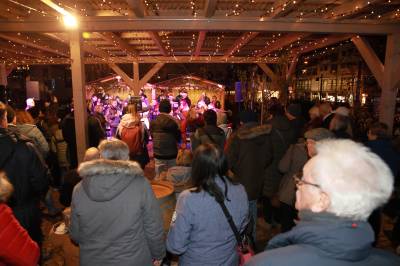 Die Spaziergänger hören der Stadtkapelle zu.